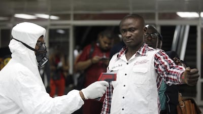 A Nigerian health official uses a thermometer to screen a person at the arrival hall of the international airport in Lagos, Nigeria. Etihad Airways is closely monitoring the Ebola outbreak in West Africa. Sunday Alamba / AP Photo