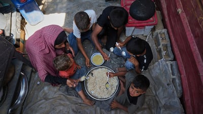 A woman living in a camp for displaced people in Al Mawasi, southern Gaza, feeds her children rice and lentil soup during Eid Al Adha. AP Photo