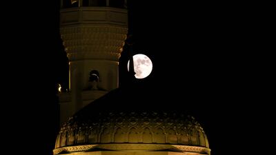The harvest moon glows behind a mosque in Kuwait City, Kuwait. AFP
