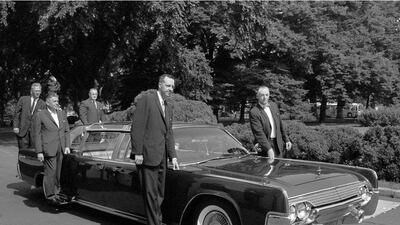 FILE - In this June 14, 1961 photo, US Secret Service agents stand on retractable stands on president John F. Kennedy's new plastic-topped Lincoln Continental limousine outside the White House, after its delivery in Washington. The car has three roof combinations, a rear seat that can be raised and lowered, retractable foot stands for Secret Service men, two two-way radio telephones, and a master control panel for power accessories. Henry Burroughs / AP Photo