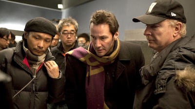 Keanu Reeves, center, the director and star of Man of Tai Chi watching playback on set. Courtesy China Film Group