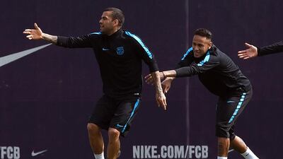 Barcelona’s Brazilian forward Neymar (right) and Barcelona’s Brazilian defender Dani Alves joke during a training session at the Barcelona Joan Gamper Sports Center in Sant Joan Despi, near Barcelona on April 12, 2016, on the eve of their Champions League quarter-final second leg football match between Atletico de Madrid and FC Barcelona. / AFP / LLUIS GENE