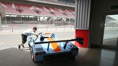 Tim Murdoch, a race mechanic from the UK, wheels David Field's SR5 Radical sports car back into the pits at Dubai Autodrome. The SR5 is one of four classes of racer that competes in the Gulf Radical Cup.