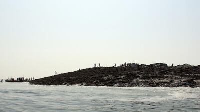 Pakistani residents arrive by boat to an island that appeared some two kilometres off the coastline at Gwadar after an earthquake. A small island of mud and rock created by the huge earthquake that hit southwest Pakistan has fascinated locals but experts -- who found methane gas rising from it -- say it is unlikely to last long. Behram Baloch / AFP Photo