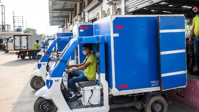 A delivery rider in a Mahindra Treo Zor electric vehicle departs a loading bay at a BigBasket warehouse in Noida, Uttar Pradesh, India. Photo: Bloomberg