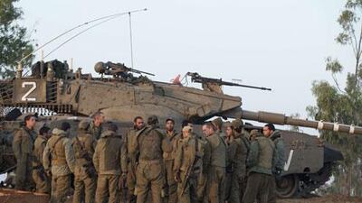 Israeli soliders on the Israel-Gaza border gather at a deployment area. A planned ground assault has been suspended by Israel overnight.