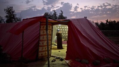 Syrian refugee Ghaziyya Alsaad, 58, offers evening prayers, inside a tent at a settlement near the Syrian border on the outskirts of Mafraq, Jordan. Muhammed Muheisen / AP Photo