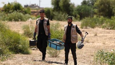 Officers carry away an unexploded projectile. AFP