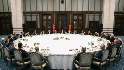 Turkish president Recep Tayyip Erdogan, centre, hosts an iftar dinner for members of the religious affairs administration around the squash-court-size table. EPA
