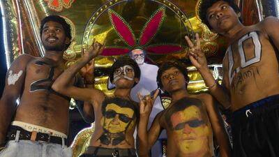 Fans display body paint with a portrait of Rajinikanth before attending the early morning show. AFP