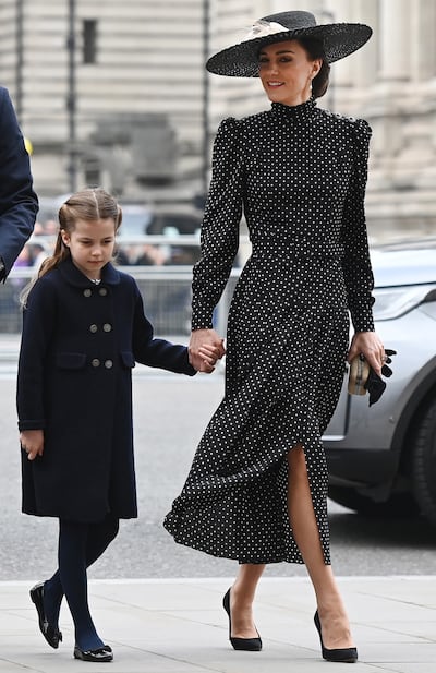 Kate, Duchess of Cambridge wears a black and white polka dot dress by Alessandra Rich as she arrives for the service of thanksgiving for the life of Prince Philip, the late Duke of Edinburgh, with her daughter, Princess Charlotte, at Westminster Abbey, London, on March 29, 2022. EPA