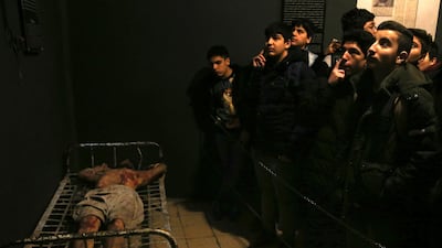 In this Jan. 7, 2019 photo, Iranian schoolboys look at an exhibition at a former prison run by the pre-revolution intelligence service, SAVAK. AP