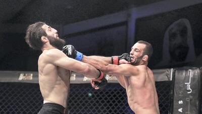 Jarrah Al Selawi, right, lands a punch on Abdoul Abdouraguimov during their weltweweight title bout at Brave CF 27 at Mubadala Arena. Victor Besa / The National
