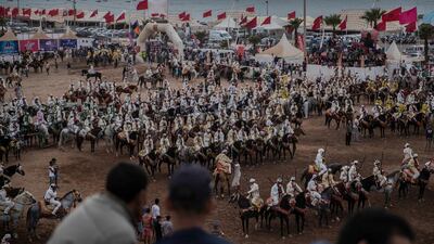 People watch as horse riders wait for their turn to take part in an equestrian show known as Fantasia or Tabourida, in the coastal town of El Jadida, Morocco.
