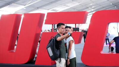 People take selfies at the UFC fan zone. Yas Island, Abu Dhabi. Chris Whiteoak / The National