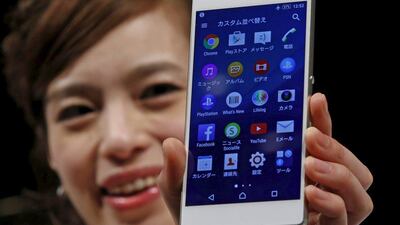 A model poses with Sony's new Xperia Z4 smartphone after a news conference in Tokyo on April 20, 2015. Sony Corp on Monday unveiled the new high-end Xperia handset featuring an aluminium frame and a 5.2-inch screen, showing it is still in the smartphone race even as it scales down its struggling mobile operations. Toru Hanai / Reuters