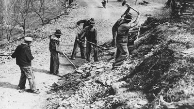 In this March 1936 picture, workers build a new farm-to-market road along Knob Creek in Tennessee. The New Deal was a try-anything moment during the Great Depression that remade the role of the federal government in American life. AP