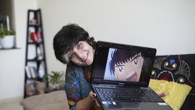Syrian voice actress Amal Hawijeh is photographed with Captain Majid, a character she voiced. (Sarah Dea / The National)