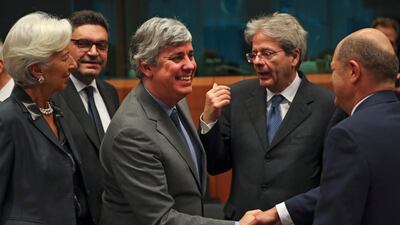 Eurogroup President Mario Centeno, centre, shakes hands with German Finance Minister Olaf Scholz, right, next to European Central Bank President Christine Lagarde, left, Cyprus' Economy Minister Constantinos Petrides, second left, and European Commissioner for Economy Paolo Gentiloni, second right, during a meeting of European Union Finance Ministers in Eurogroup format at the Europa building in Brussels. AP Photo