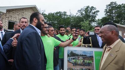 Houston Mayor Sylvester Turner watches a volunteer take a selfie with Saudi Crown Prince Mohammed bin Salman in front of a Habitat for Humanity home in Houston. Steve Gonzales / AP Photo
