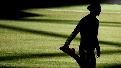 The silhouette of Sweden forward Zlatan Ibrahimovic is seen as he warms up for a training session. AFP