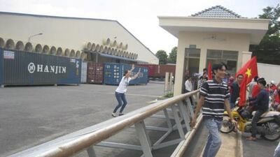 An employee, left, of a Chinese company raises her hands while trying to stop protesters in Binh Duong province on May 14, 2014. Reuters