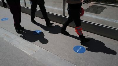 Shadows of Tour Eiffel workers are cast on the access lane with social distancing stickers during a presentation of the security measures at the Eiffel Tower in Paris. AP