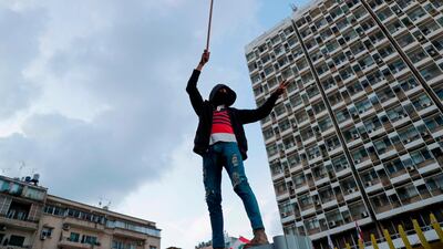 A Lebanese demonstrator waves the national flag during a protest in Beirut. AFP