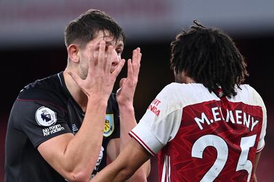 Burnley's James Tarkowski, left argues with Arsenal's Mohamed Elneny. AP