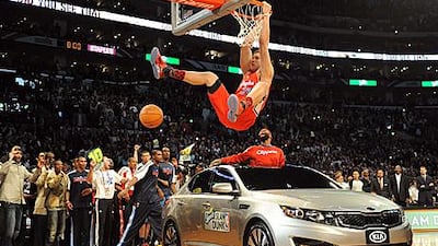 Blake Griffin from the LA Clippers slam dunks over a car with teammate Baron Davis inside.