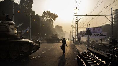 Egyptians walk past a line of tanks stationed outside the presidential palace. Marco Longari / AFP