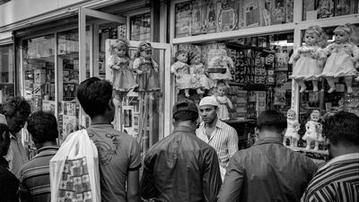 A merchant faces a wall of customers outside his shop in downtown Abu Dhabi on the first Friday in the month of April. With monthly pay cycles, Fridays bring out large crowds often shopping for gifts to send home to family. Brian Kerrigan / The National