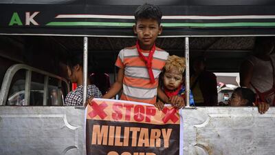 Young protesters hold a sign during a demonstration against the military coup in Yangon. AFP
