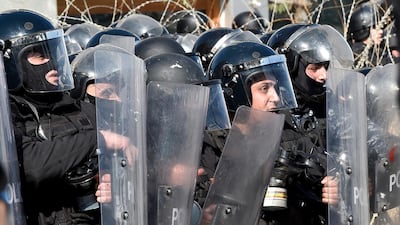 Anti-riot policemen react as protesters throw stones during a demonstration against parliament session on 2020 budget in downtown Beirut. EPA