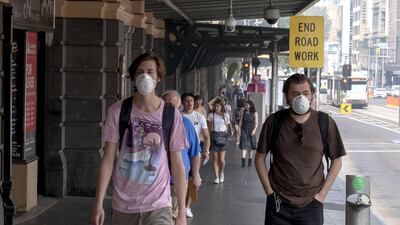 Melbourne commuters walk wearing a mask as the city suffers hazardous air quality in Melbourne, Australia. Getty