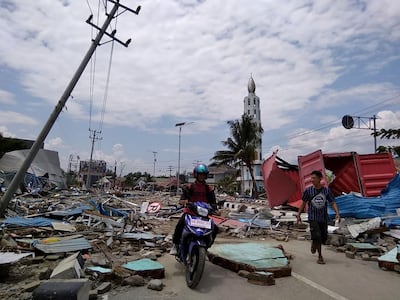 Residents make their way along a street full of debris after an earthquake and tsunami hit Palu, on Sulawesi island on September 29, 2018. Muhammad Rifki / AFP