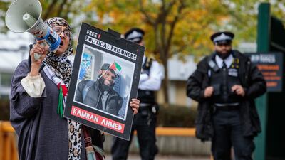 An activist holds a sign bearing an image of hunger striker Kamran Ahmed outside Woolwich Crown Court. Getty Images