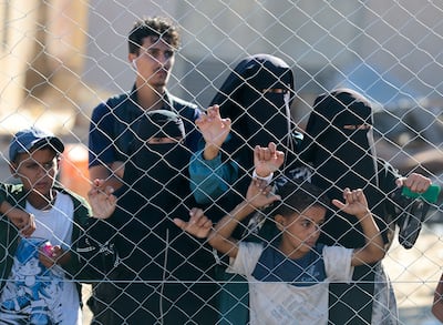 People watch as a van carrying the bodies of Palestinians who had been held in Israel during the war arrives at Nasser Hospital in Gaza on Tuesday. Reuters