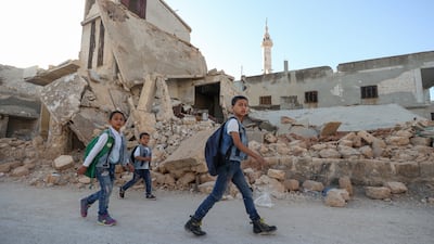 Children walk among the rubble as they attend the first day of school in a village in the countryside of Syria's northwestern Idlib province.