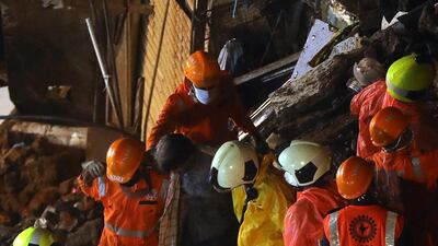 Rescuers help a man rescued from the rubble after the partial building collapse in south Mumbai. Reuters