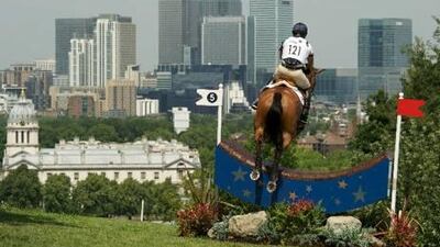 Showjumping during the London Olympic's equestrian test event at the cross country course in Greenwich Park, with Canary Wharf in the background.