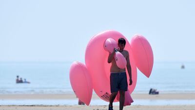 Beach-goers enjoy the sunshine by the sea in Camber Sands, southern England, during a heatwave in Britain. AFP