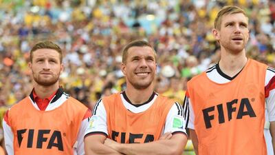 Shkodran Mustafi, left, with German international teammates Lukas Podolski, centre, and Per Mertesacker during the 2014 Fifa World Cup. Andreas Gilbert / EPA