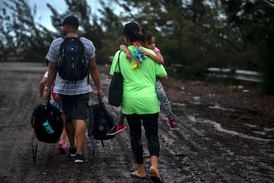 A family walks on a road after being rescued from the flood waters of Hurricane Dorian, near Freeport, Grand Bahama, Bahamas. AP Photo