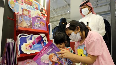 Girls look at children's books at the month-long fair.