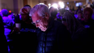 An anxious voter refreshers his browser to get the results as Mr Warnock's party continues behind him. Getty / AFP
