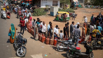 People stand in a queue with their empty LPG cylinders outside a gas agency in Ahmedabad, India. Reuters