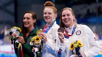 Gold medallistLydia Jacoby, centre, of Team USA shows off her gold medal after winning the women's 100m breaststroke final.