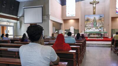 Two people are seated per pew during services St Joseph's Catholic Church.
