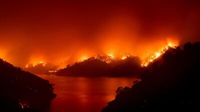 Flames from the LNU Lightning Complex fires burn around Lake Berryessa in unincorporated Napa County on Wednesday, August 19, 2020. Fire crews across the region scrambled to contain dozens of wildfires sparked by lightning strikes. AP Photo